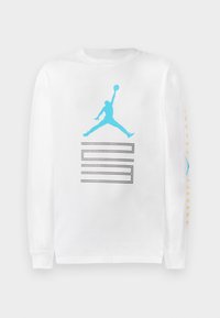 T-shirt bianco a maniche lunghe in cotone con logo "Jumpman" blu e design a blocchi grigi sul fronte; dettagli testuali gialli sulle maniche.