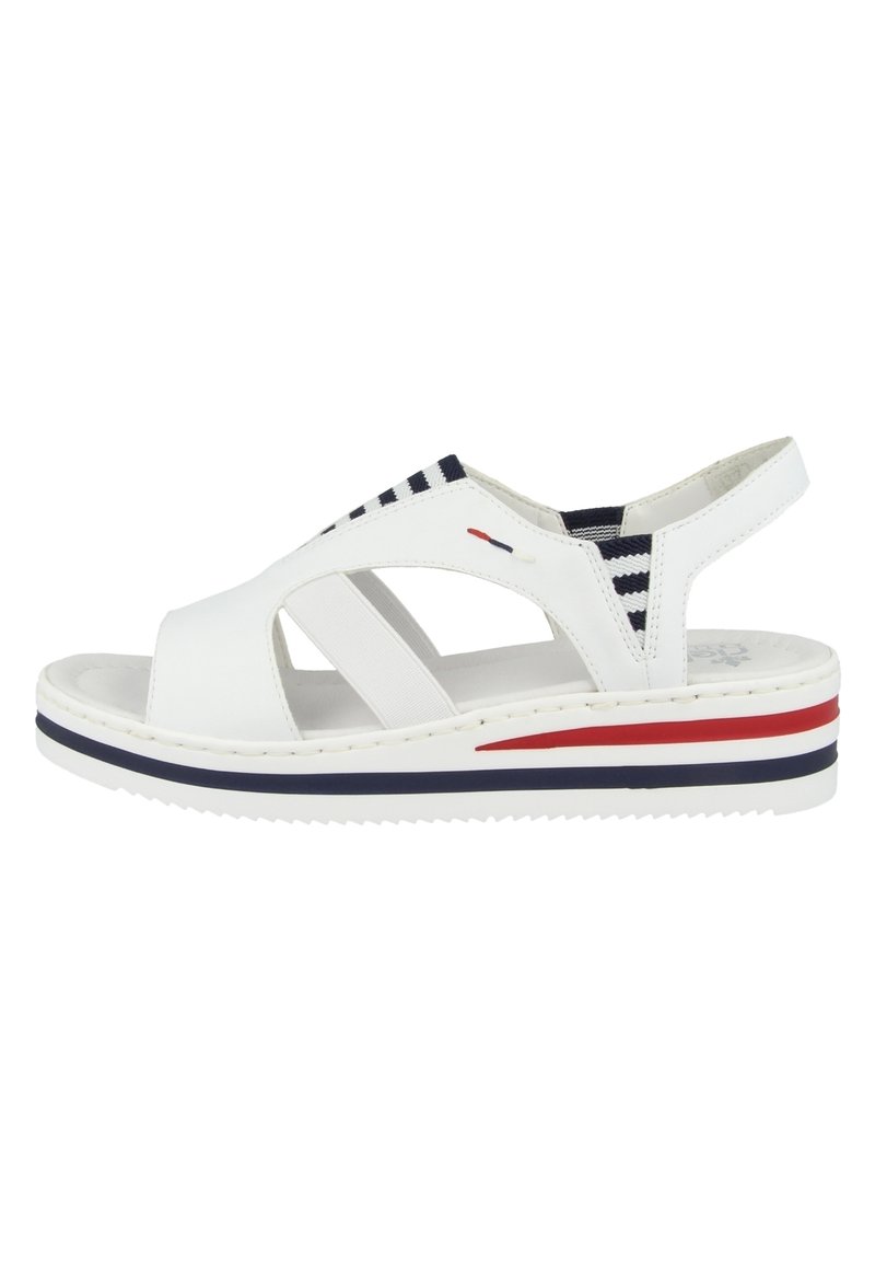 Weiße Sandale mit offenen Zehen und elastischen Riemen, ausgestattet mit einer Keilsohle. Die Sohle hat rot-weiß-blaue horizontale Streifen. Strukturierte Oberfläche.