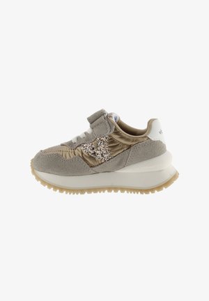 Zapatilla con velcro hecha de una combinación de ante gris claro y material satinado, con un acento dorado brillante y un talón blanco. Suela de goma para mayor tracción.