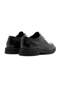 Scarpe nere di pelle con finitura liscia, punta rotonda, pannello posteriore a contrasto e suola in gomma con scanalature per la trazione.