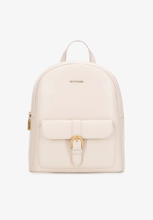 Zaino in pelle beige a forma arrotondata, con pattina frontale, accessori in oro e manico superiore. Presenta una tasca laterale con zip e un logo.