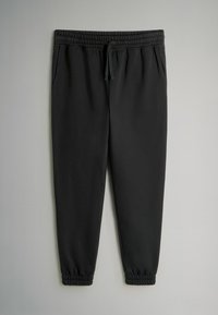 Sorte sweatpants lavet af blødt materiale, med en elastisk talje og snor, sidelommer og elastiske manchetter ved anklerne.