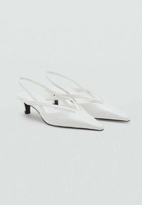 Valkoiset nahka slingback-korot, joissa on terävä kärki, kapeat nilkkahihnat ja pieni musta korko. Sujuva pinta, jossa minimaalinen yksityiskohtaisuus.