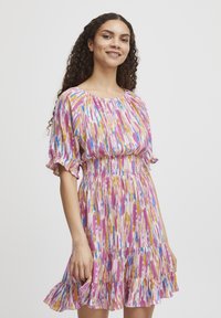 Rochie cu mânecă scurtă, cu talie elastică, fustă în volane și un model vibrant de roz, galben, albastru și alb pe un material ușor.