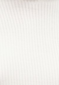 Biały prążkowany materiał z cienkimi, równomiernie rozmieszczonymi pionowymi liniami. Miękka faktura, lekki materiał, odpowiedni do odzieży lub tapicerki.