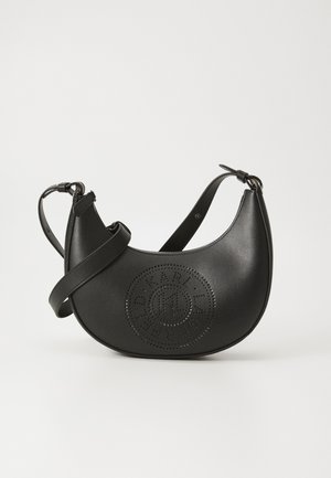 Sac à main en cuir noir de forme incurvée, avec un design circulaire perforé et une bandoulière réglable pour un usage en bandoulière.
