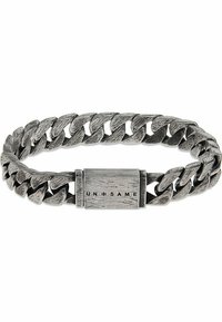 Silverfärgad metallarmband med ett vävt kedjemönster, en texturerad yta och ett rektangulärt spänne med "UN=SAME" ingraverat.