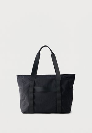 Czarna prostokątna torba typu tote z dwoma długimi uchwytami i bocznymi kieszeniami, wykonana z lekko teksturowanego materiału, prezentowana na białym tle.
