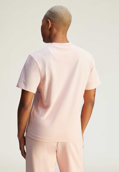 Pink cotton T-shirt featuring short sleeves, a crew neck, and a relaxed fit. The fabric has a soft texture and understated design.