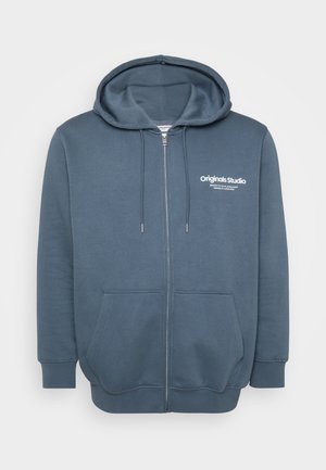 Dunkelblauer Reißverschluss-Hoodie. Mit einer Kapuze mit Zugband, zwei Fronttaschen und weißem Logotext auf der linken Brust. Weicher, strukturierter Stoff.
