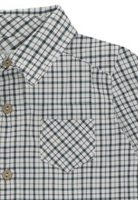 Camisa blanca con un patrón de cuadros en verde y marrón, botones beiges y un bolsillo en el pecho izquierdo debajo de un cuello puntiagudo.