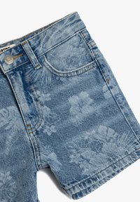 Shorts de denim azul claro con un patrón desvaído, diseño de cinco bolsillos, cierre de botón metálico y costuras en contraste a lo largo de las costuras.