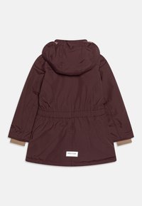 Bordeauxfarvet hættejakke med elastisk taljebånd og tan ærmekanter. Glat tekstur med en logomærkat ved kanten.
