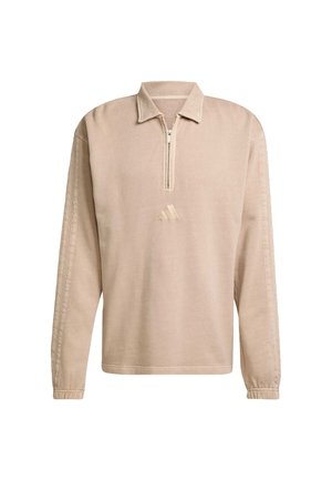Beige pullover with a quarter zip, long sleeves, and subtle side ribbing. Features a small, embossed logo on the front. Soft texture.