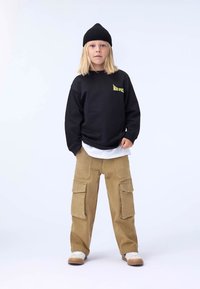 Black sweatshirt with "Mars Space" logo, layered over a white shirt; khaki cargo pants with large pockets; black knit beanie; white sneakers.