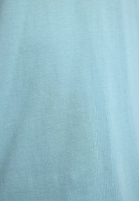 Lichtblauwe katoenen stof met een gladde textuur en een subtiel heatherpatroon, ideaal voor casual kleding of om te lagen.