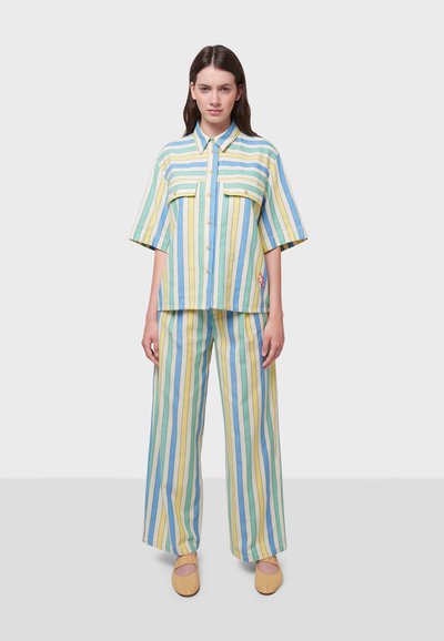 Korte mouwen gestreept shirt en wijde broek in blauw, geel en groene tinten met twee borstzakken en bijpassende schoenen. Katoenen materiaal.