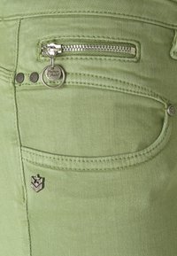 Green denim jeans featuring a front pocket with a zipper, silver hardware accents, and contrasting stitching details.