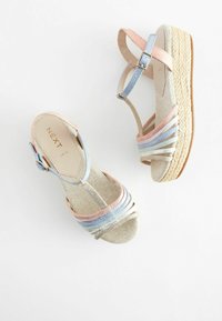 Kengät, joissa on espadrilles-tyyppinen korokepohja, beige kudottu pohja, pastelinsiniset, vaaleanpunaiset ja kermaiset hihnat. Säädettävä nilkkakiinnitys.
