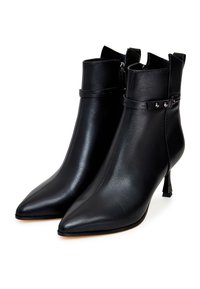 Bottines en cuir noir avec un bout pointu, fermeture à glissière, languette arrière, et sangle au niveau de la cheville avec des accents en métal.