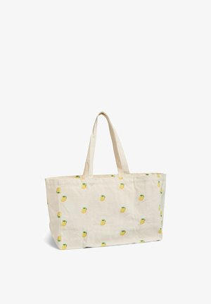 Platnena torba v kremni barvi z odtisi limon in dvema naramnima trakovoma, prikazana na belem ozadju.