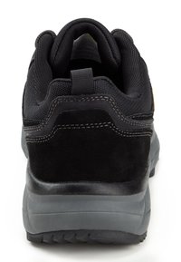 Black athletic shoe featuring a textured mesh upper, suede accents, and a sturdy rubber sole with visible tread pattern. Reinforced heel tab.