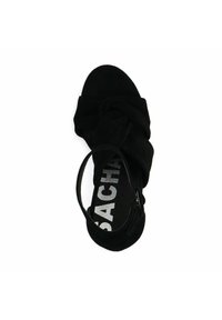 Zwarte high-heeled sandaal van zacht suède, met gedraaide banden en een dunne enkelband. Logo in zilver gedrukt op de binnenzool.