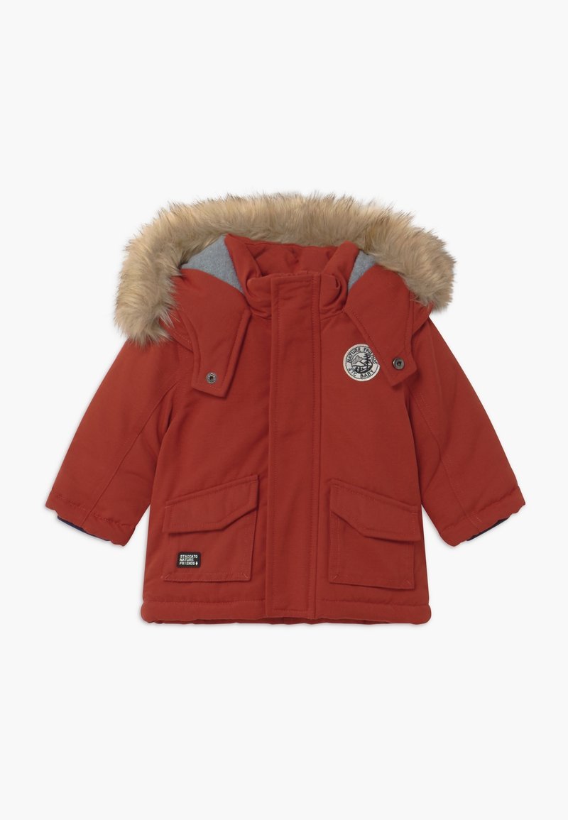 Giacca invernale rossa con cappuccio in pelliccia sintetica, fodera grigia, chiusura con bottoni a pressione, due grandi tasche frontali e una patch decorativa sul petto.
