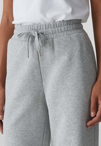 Grijze sweatpants met een elastische tailleband en een trekkoord. Gemaakt van zachte stof, met een relaxed fit en zijzakken.