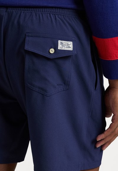 Shorts bleu marine en tissu léger, dotés d'une taille élastique, de poches latérales et d'une poche arrière à rabat avec une étiquette de marque.