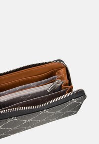 Billetera con cremallera en cuero negro con costuras grises, que cuenta con múltiples compartimentos en tonos marrón claro y gris para tarjetas y efectivo.