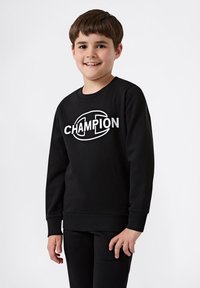 Sudadera negra de manga larga, con un gran logo blanco de "CHAMPION" en el frente. Tejido texturizado y diseño de ajuste relajado.