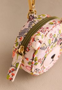 Kerek, rózsaszín szövetzsák virágmintákkal, zöld cipzárral és aranyszínű fémalkatrészekkel. Elöl mackóarc dizájn található, és lapos pántja van.