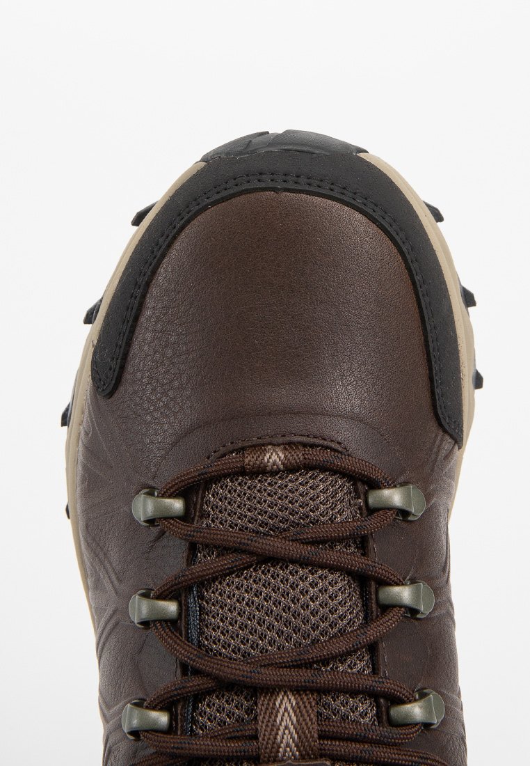 Zapato de senderismo de cuero marrón con cuello acolchado negro, lengüeta de malla y cordones marrones. Presenta una suela de goma con dibujo para tracción.