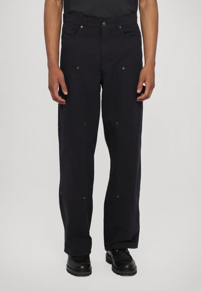Schwarze, weite Cargo-Hosen aus Baumwollmischung, mit frontalen Taschen, Druckknopfverschlüssen und verstärkten Nähten, die über eine glatte Textur verfügen.