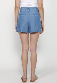Denim kratke hlače, svetlo modre, s ravnim krojem in zadnjimi žepi. Imajo ravno elastiko in zavihane robove.