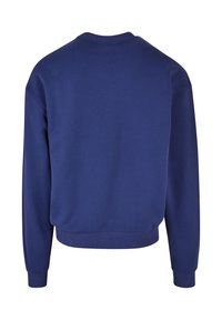 Sudadera azul marino con cuello redondo, mangas largas y dobladillo acanalado. Textura suave, diseño minimalista y sin logotipos visibles.
