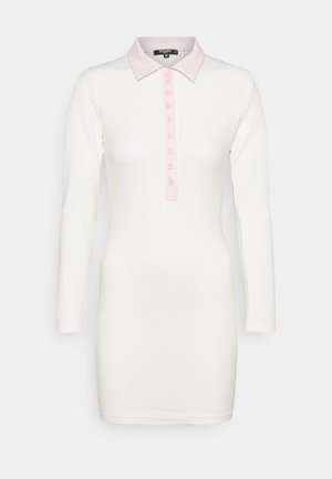 Geripptes Kleid in Weiß mit langen Ärmeln, einem hellrosa Kragen und einer Knopfleiste. Es hat ein figurbetontes Design und eine weiche Textur.