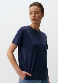 Navyblauw T-shirt met korte mouwen en ronde hals, gemaakt van een soepele stof, met een relaxte pasvorm en een zijzakdetail.