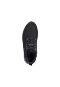 Zapatilla negra con cordones, de textura suave, con cuello acolchado y suela blanca. Presenta un logo en el lado interno y un diseño de punta redonda.
