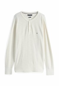 Long-sleeve, cream-colored henley shirt, featuring a ribbed texture, three-button placket, and a small logo on the left chest.