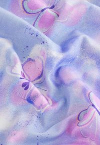 Helles Blaues Gewebe mit glatter Textur, das Schmetterlingsmuster in lila und rosa Tönen zeigt, akzentuiert durch sanfte, verschwommene Flecken.