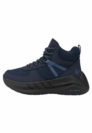 Donkerblauwe hoge sneaker met dikke zwarte zool, vetersluiting aan de voorkant, panelen van stof en leer, en “GIESSWEIN” branding op de hiel.