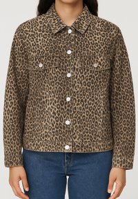 Lietuvos leopardų rašto džinsinė striukė su apykakle, priekiniais mygtukais, dviem krūtinės kišenėmis ir šiek tiek tekstūros, derinama su mėlynais džinsais.