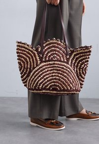 Πλεκτή τσάντα tote με καφέ και κρέμα σπειροειδή μοτίβο, με κυματιστή κορυφή και καφέ δερμάτινες λαβές.