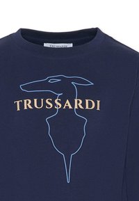 T-shirt bleu marine avec un contour bleu clair de la silhouette d'un chien et le texte beige "TRUSSARDI" au niveau de la poitrine. Tissu doux, design à col rond.