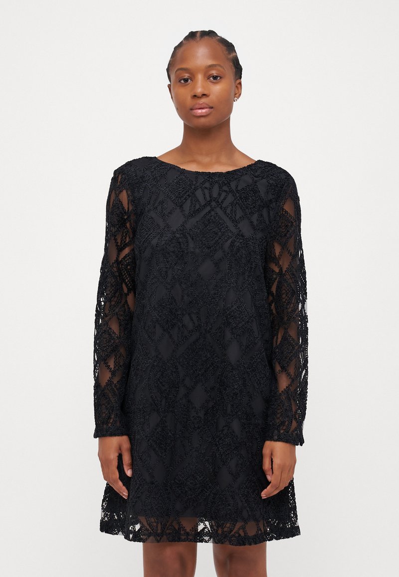 Črna čipkasta obleka z dolgimi prosojnimi rokavi, ki se ponaša z zapletenimi geometrijskimi vzorci. Ovratnik je okrogel, tkanina pa ima teksturirano površino.