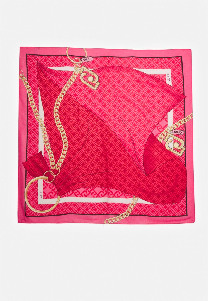 Foulard di seta rossa con un motivo geometrico, dettagli in catena dorata e un bordo decorativo. Include particolari come un grande anello e un'etichetta.