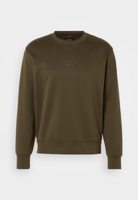 Sweat-shirt vert olive avec un col rond, des poignets et un ourlet côtelés. Présente un logo en relief subtil au niveau de la poitrine. Texture de tissu lisse.