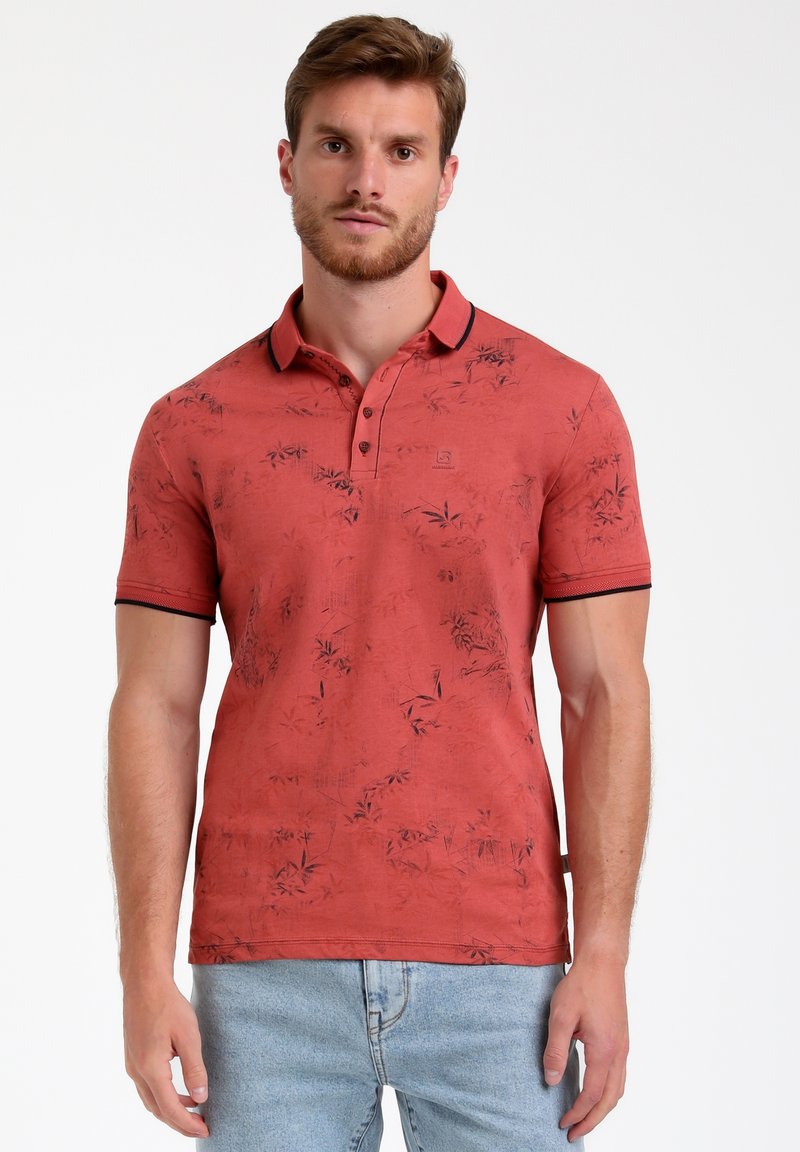 Polo rosso con un motivo floreale, maniche corte e colletto a coste nero. Presenta bottoni e un logo sul lato sinistro del petto.